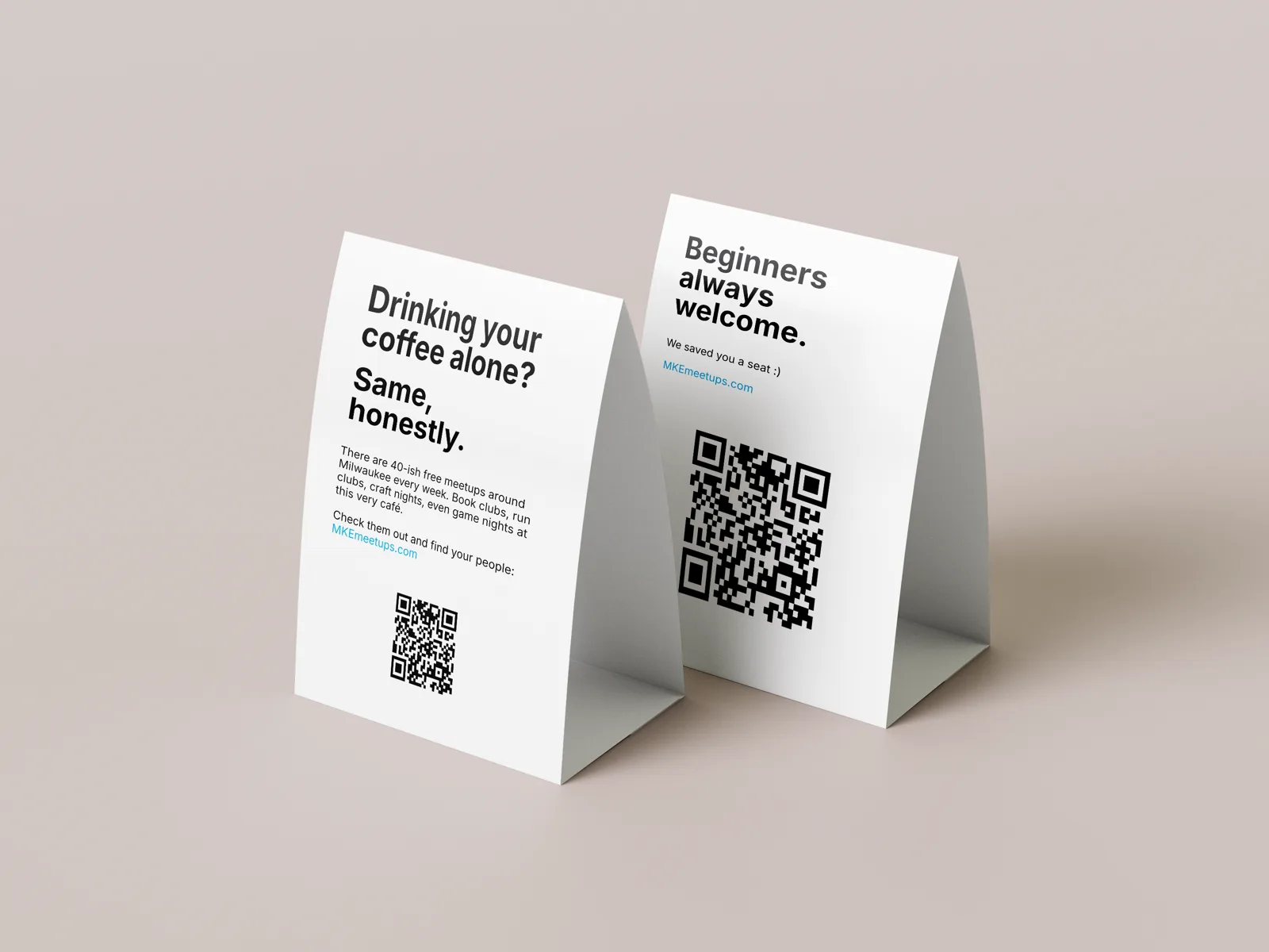 The counter card rendered as a folded table tent, front and back: the ‘drinking your coffee alone?’ front and the ‘beginners always welcome’ back, each with a QR code.